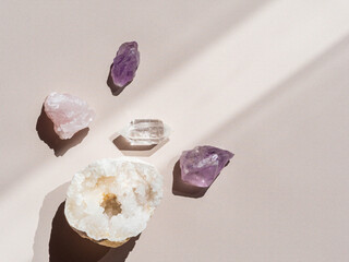 Collection of crystals quartz and amethyst on a beige background with shadows from sunlight