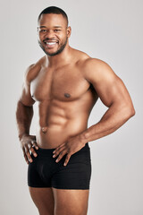 Fototapeta premium Black man, portrait and muscle in studio with underwear for fitness or health with confidence for body. Wellness, strength and bodybuilding competition in America with pride for power training.