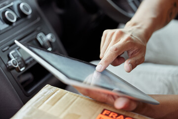 Hands, tablet and delivery man in van with box, supply chain and online checklist for professional distribution. Courier, shipping and driver in car with package, digital app and transport schedule.