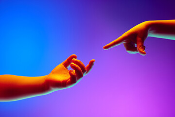 Kids hands gesturing against gradient blue purple background in neon light. Children hands reaching...