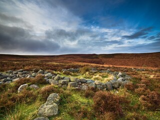 A reconstructed Bronze Age hut circle on Ilkley moor in Yorkshire. The circle in in the heather with superb views. It is a beautiful day.