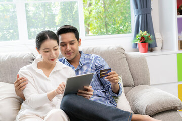 Obraz premium young couple use credit card purchase online at home