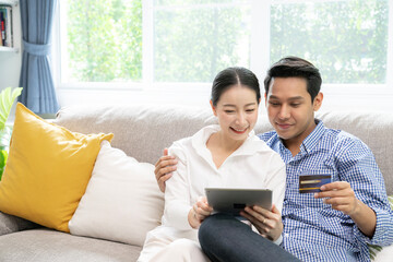 Fototapeta premium young couple use credit card purchase online at home