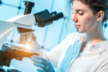 young female student studying biopsy samples in a cancer medical laboratory
