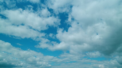 Cumulus Cloudscape. Beautiful Movement Of Puffy Fluffy White Clouds Fly Across Clear Blue Sky.