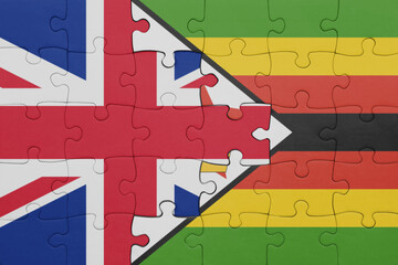 puzzle with the colourful national flag of zimbabwe and flag of great britain.