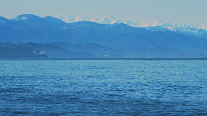 Wavy Black Sea Between Snowy Mountains. Sea By Snow Covered Mountains.