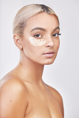 Studio portrait, skincare and woman with eye mask for beauty, skin glow and cosmetics with...