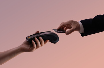 Two hands engaging in an electronic payment with a contactless credit card