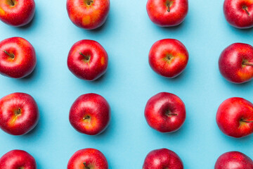 Many red apples on colored background, top view. Autumn pattern with fresh apple above view