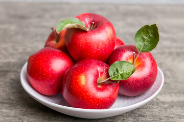 juicy red apples in a bowl or plate on the table top view. Copy space