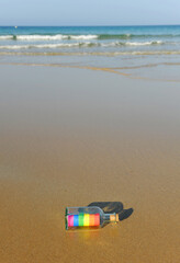 LGTBI+ pride message in a bottle on the seashore