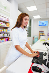 Beautiful pharmacist working and standing in a drug store and doing a stock take. Portrait of a...