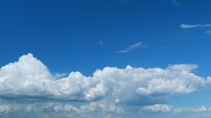 Beautiful big and fluffy clouds motion at sunny day in blue sky. White clouds floating in the blue...