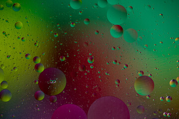 Colorful oil drops floating on the water. Abstract Purple and yellow water bubbles background.