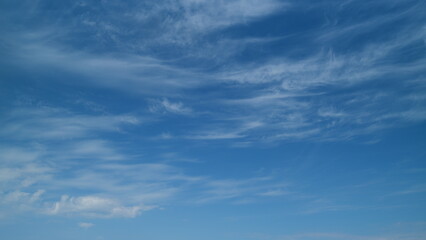 Transparent cloudscape nature background. Beautiful white cirrus clouds moving high over blue sky...