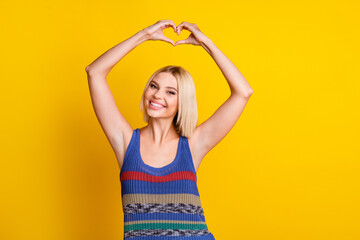 Portrait of young sweet beautiful woman student in singlet showing love symbol demonstrate respect...