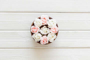 Flowers buds in wooden bowl, roses top view