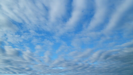 Blue sky background with cirrocumulus clouds. Sunlight and sun ray at sunshine on sunset. Timelapse.