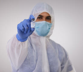 Healthcare, vial and doctor with vaccine in studio with face mask, gloves and biohazard suit....
