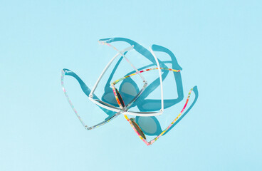 Sunglasses on a bright blue background. Ctreative summer sunlight concept. Minimal creative summer party lifestyle idea.