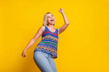Photo of young overjoyed girlfriend in jeans and singlet dancing at nightclub raised fists up...