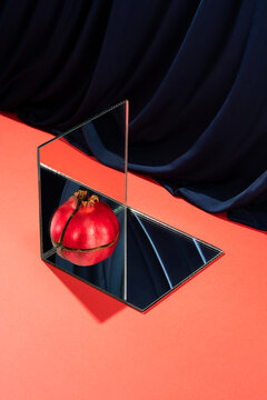 Reflections of a quarter pomegranate on the mirrors making a whole