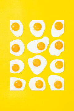 Sunny side up eggs arranged as rectangle shape on yellow background