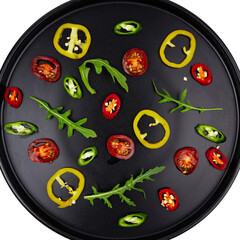 Black plate with sliced vegetables pattern, top view