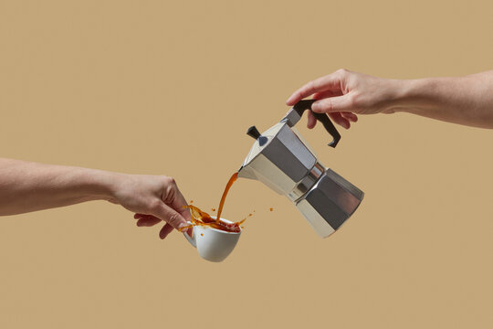 Close up of male hands pouring coffee from moka express into cup
