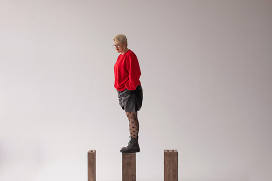 Curvy woman standing on wood block 
