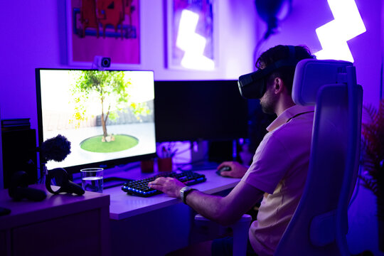 Young adult gamer playing using VR headset on computer PC - Powered by Adobe