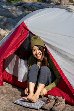 A happy camper taker off hiking boots