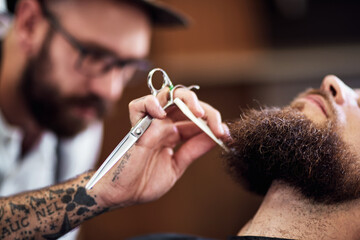 Beard, client and man in barbershop with scissors, cut and tools for trendy facial hair care at...