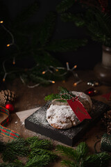 Christmas stollen cake on a wooden box on a rustic background. Traditional handmade German Christmas dessert. Fruit bread Stollen with nuts, raisins and marzipan.