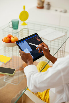 Crop woman working on tablet in loft office