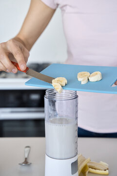 Banana being added to blender for smoothie 