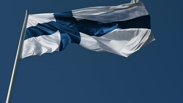 fluttering national flag of Finland against the blue sky 