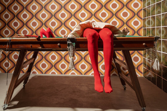 Red Tights and Heels Draped Over Billiard Table