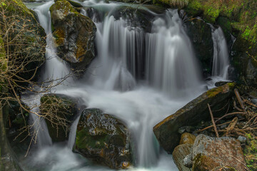 Spring creek under Simplonpass with waterfall in sunny day