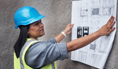 Woman, architect and reading blueprint at construction site with thinking, decision and problem...