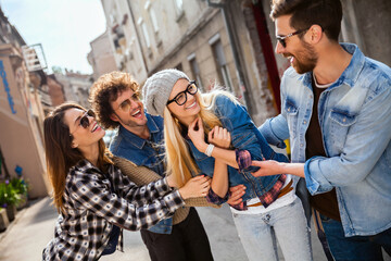 Group of young friends laughing and having fun in a city street