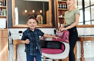 Naklejka premium Happy, hairdresser and portrait of child in barbershop for hair care, grooming and beauty. Professional, service and kid smile with pride in salon, store and appointment with woman for hairstyle