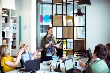 Modern office meeting with team members listening to a presentation