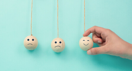 Happy smiling face spread happiness to sad faces, newton cradle concept, mental health and...