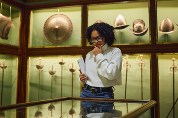 Woman visitor in the historical museum looking at art object.