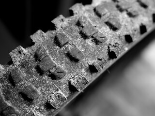 Close-up of weathered bicycle tire showing textured, dirty treads, symbolizing adventure and rugged...