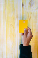 Concept payment contact less with credit card. Close up of woman hand holding card on yellow wood