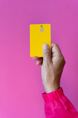 Top view in vertical format of young woman hand taking debit card on fuchsia background