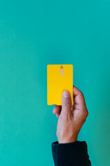 Close up seen from above of woman holding debit card with contact less symbol on turquoise...